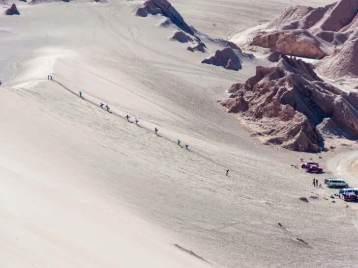 Sandboarders walking up the dunes in Valle de la Muerte