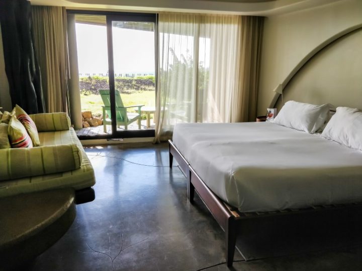 A bedroom at Nayara Hangaroa with large windows out to a sea-facing terrace
