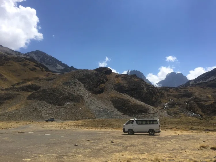 A mini bus in stark Andean scenery in Bolivia, just one of the transport options available to tourists travelling in Bolivia. 