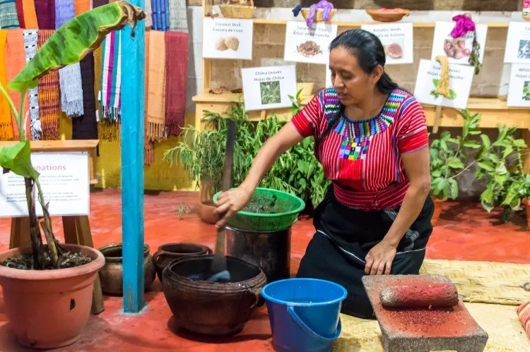 A Mayan woman in a weaving cooperative in San Juan La Laguna dyes yarn using organic dye