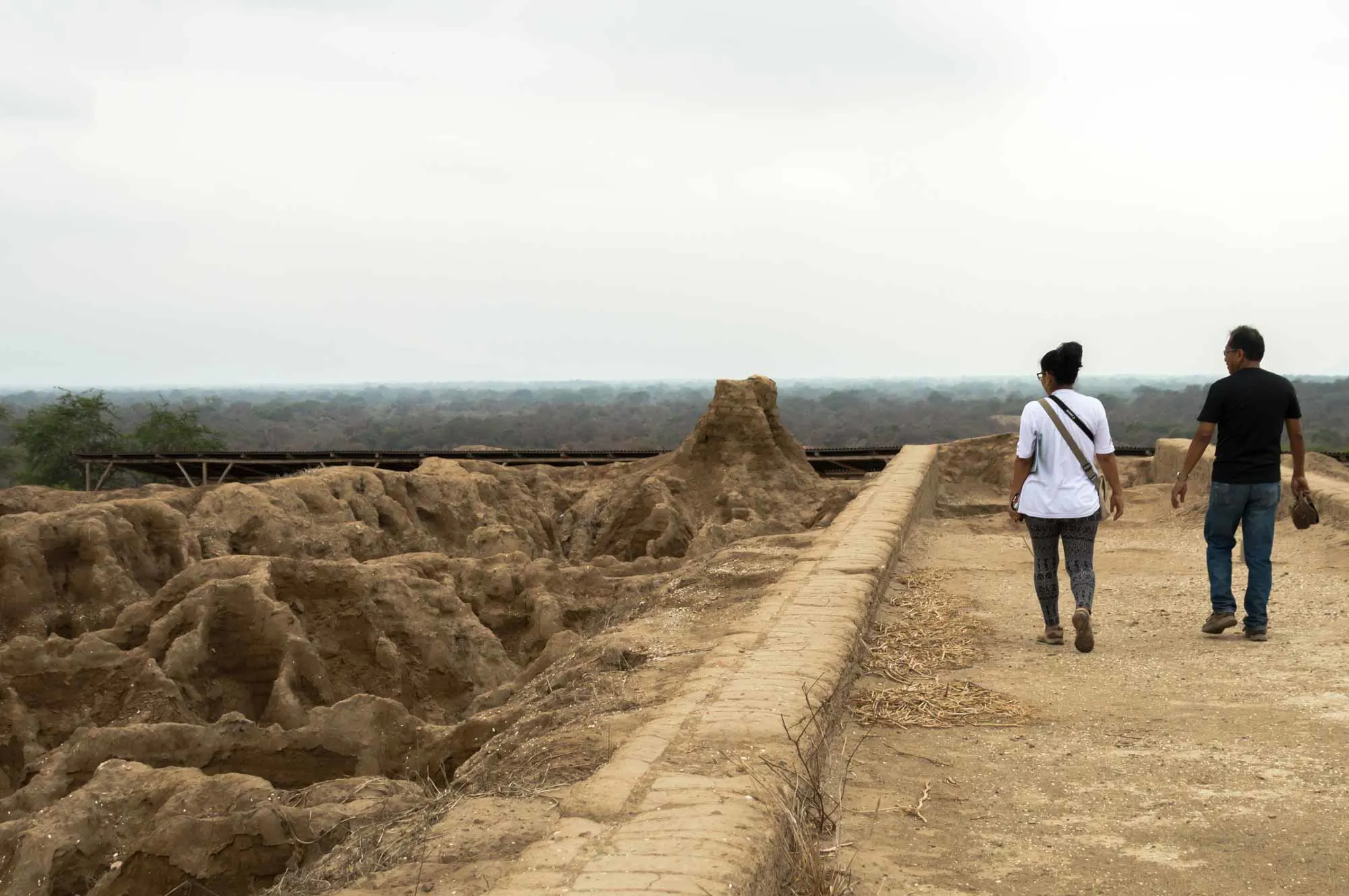 Two people walk on the walls of the Huaca Las Ventanas in what is now the Santuario Historico Bosque de Pomac in northern Peru. 