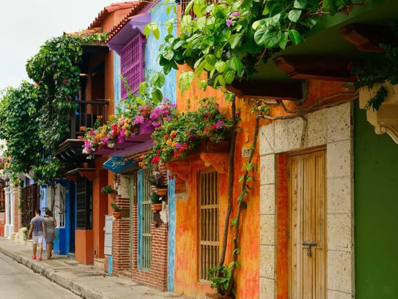 The streets of Colonial Cartagena - brightly painted and covered in flowers. Discover them on these South America Backpacking Routes 