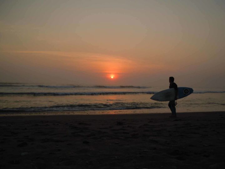 A surfer at sunset on Huanchaco beach near Trujillo in Peru