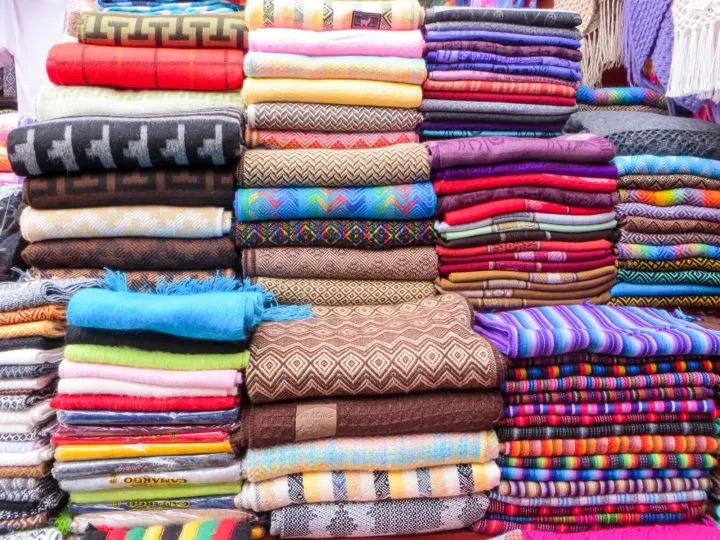 Hand-woven textiles in the market of Pisac in the Sacred Valley and an unmissable place to visit in Peru