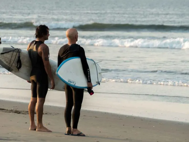 Two men survey the waves at surfing hot spot Lobitos one of the top places to visit in northern Peru