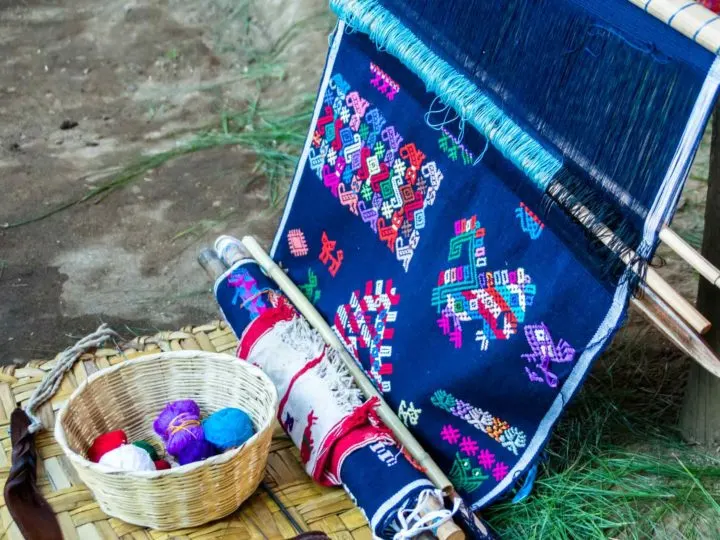 A backstrap weaving loom with a half-woven textile depicting Maya symbols in the community of Santo Domingo Xenacoj, a place to go in Guatemala for a textile workshop