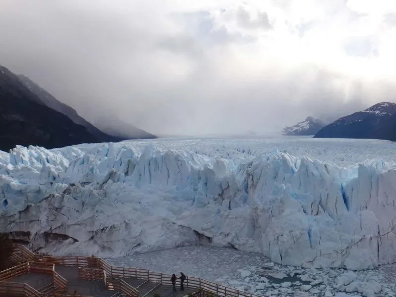 People stand on the wooden walkways in front of the snout of the Perito Moreno Glacier in Patagonia, Argentina