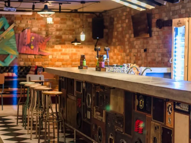 The bar made of speakers and a concrete slab in the underground space at Selina, Lima