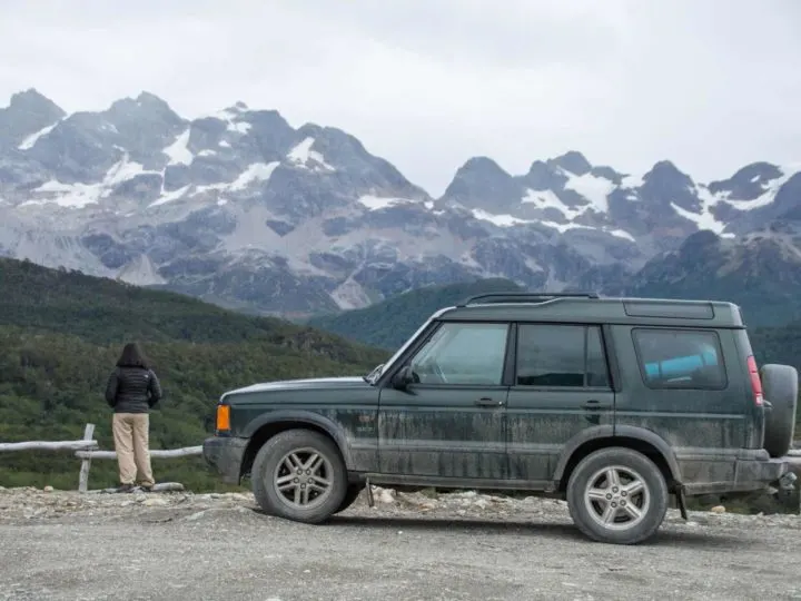 A rental car with the backdrop of the Cordillera Darwin in Chilean Tierra del Fuego, Patagonia