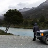 A person stands by a rental car along the Carretera Austral