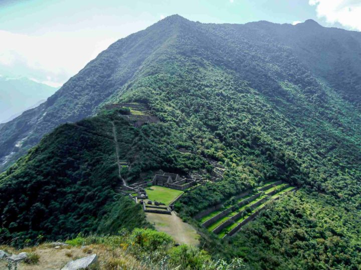 Overlooking forested mountains, terraces, and the ruins of Choquequirao in Peru. This South American trek can be extended to visit Machu Picchu.