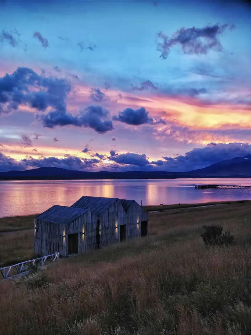 This purple sunset over Puerto Natales Chile is the perfect starting point for some of the Best South America Backpacking Routes 