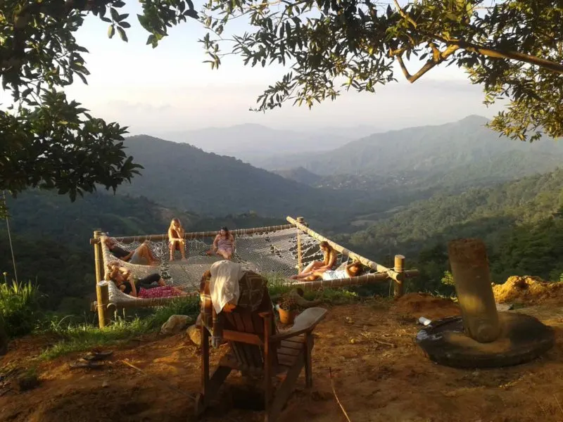Fellow travelers hang out in a group hammock overhanging the valley in Minca Colombia on these South America Backpacking Routes 