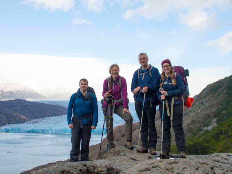 Four hikers in front of Glacier Grey while hiking the O Circuit in Torres del Paine National Park, Patagonia