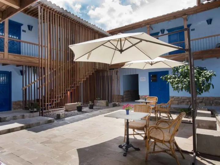 The interior patio of this boutique hotel is surrounded by light blue walls and natural wood balconies