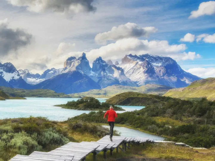A person runs down a wooden boardwalk at the Salto Chico viewpoint in Torres del Paine National Park, a short day hike