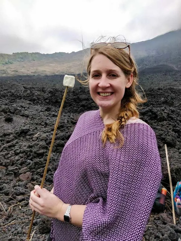 Worldly Adventurer stands with a marshmallow on Volcan Pacaya, a must-visit destination on a Guatemala itinerary