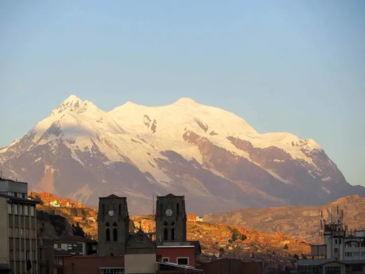 The snow-dusted peaks of Illimani are lit up in the sunrise above La Paz in Bolivia