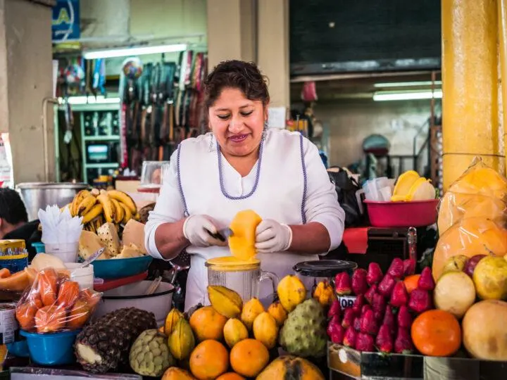 A woman peels fruit at her stall in the Mercado San Camilo, a must-visit place in Arequipa