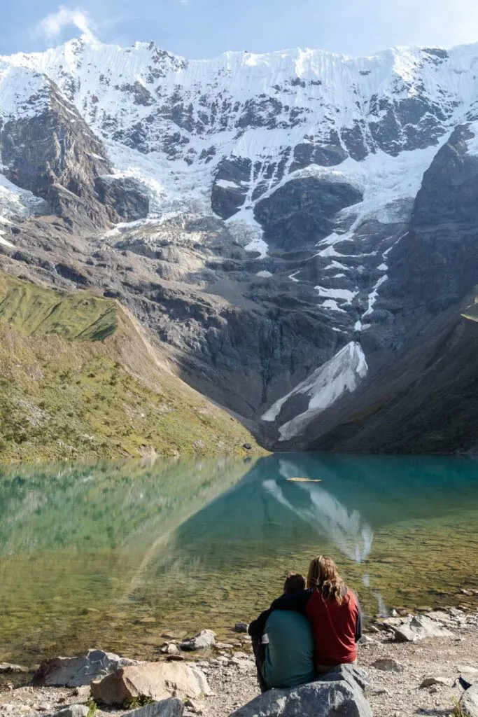 A couple sat in front of Humantay Lake the Salkantay trek, an alternative route to Machu Picchu, Peru