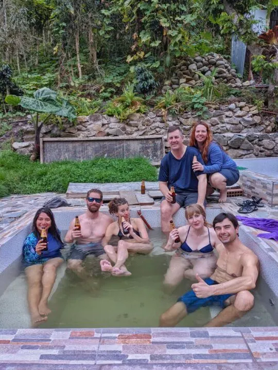 Hikers in the jacuzzi at Alpaca Expeditions' hobbit houses on the Salkantay trail