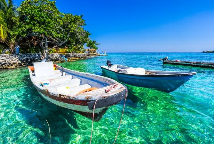 Two boats sit on crystal clear water at the Islas del Rosario