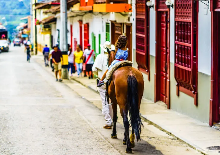 A girl riding a horse in the streets of Jardin, Colombia