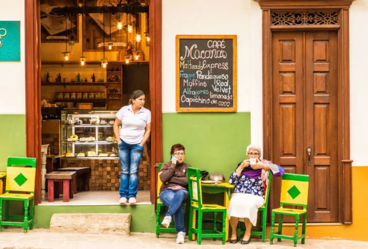Two local ladies drinking coffee outside a cafe in Jardin, Colombia 