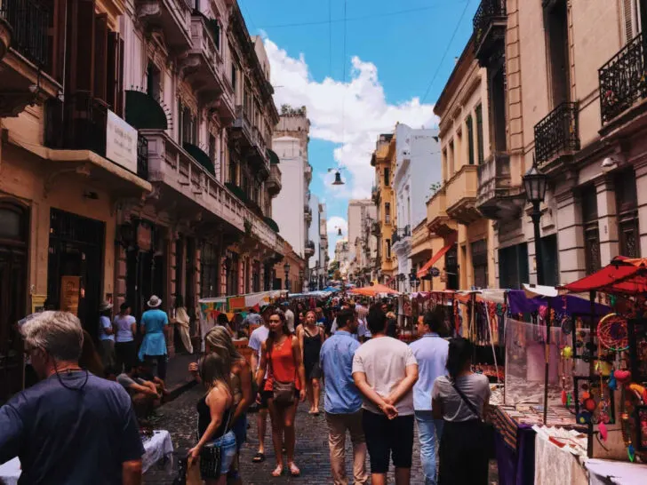 A bustling street in Buenos Aires with market traders, locals and tourists alike.
