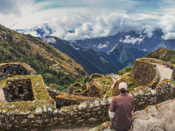 A person sitting above the Phuyupatamarca archaeological site on the Inca Trail