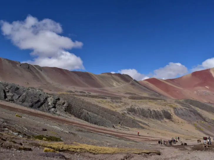 Rainbow Mountain with tour groups in the forefront. With a surge in popularity, Rainbow Mountain is a Peruvian hike we don't necessarily recommend.